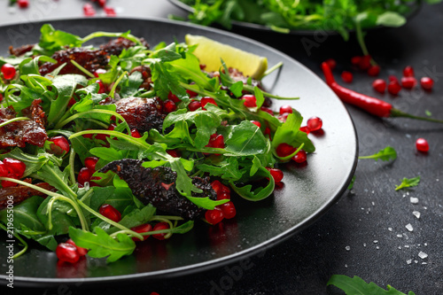 Spicy crispy duck salad with pomegranate seeds, lime and wild green rucola