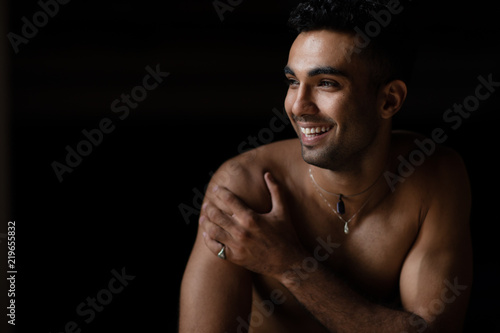 Young shirtless man laughing