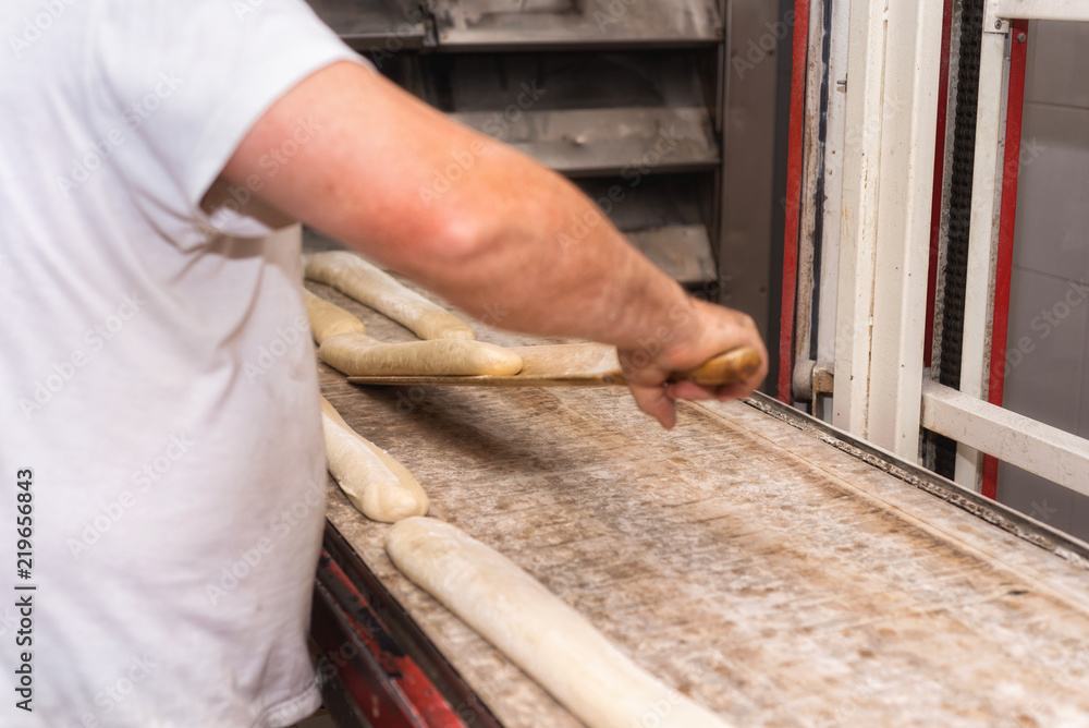 Baker preparing uncooked bread dough loaves ready to bake Baker preparing uncooked bread dough loaves ready to bake