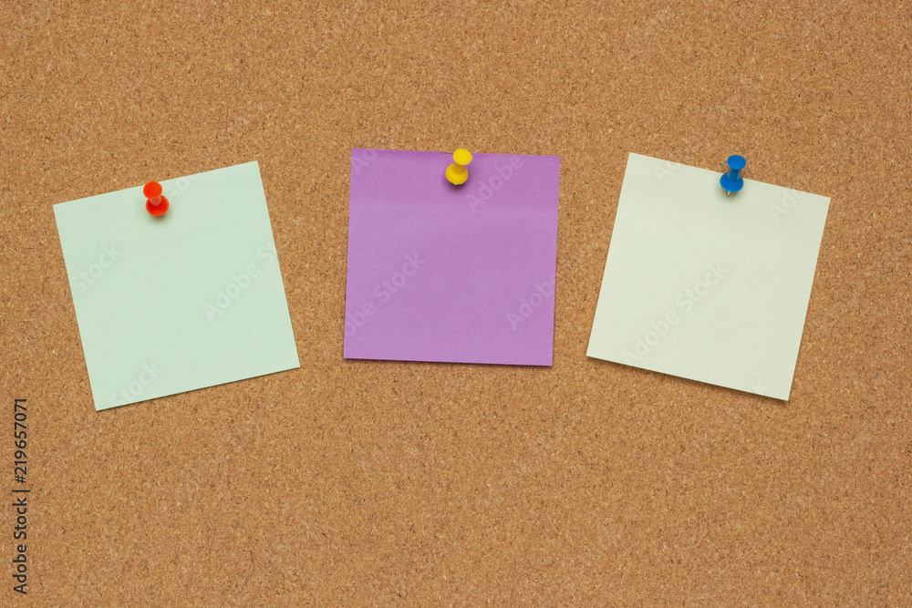 Three colorful sticky notes with pushpins and blank space, isolated on cork background, school concept Three colorful sticky notes with pushpins and blank space, isolated on cork background, school concept