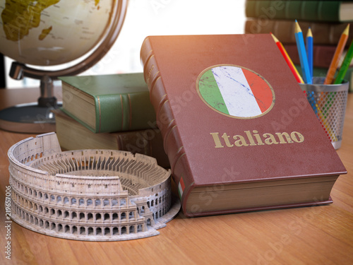 Studying and learn Italian concept. Book with flag of Italy and Coliseum on the table. photo