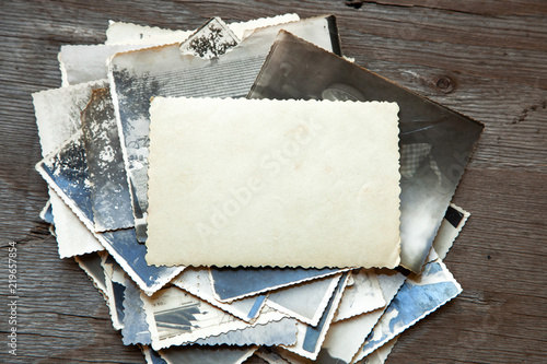 Stack old photos on table. Mock-up blank paper. Postcard rumpled and dirty vintage