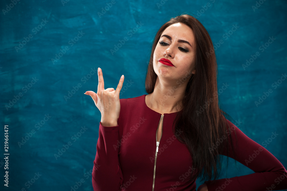 Cheerful brunette woman with red lips and long brown hair posing on blue background. Cheerful brunette woman with red lips and long brown hair posing on blue background.