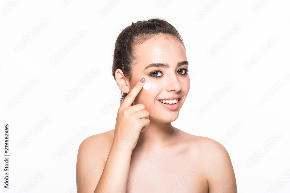 Portrait of beautiful woman applying some cream to her face for skin care isolated on white background. Skin care concept.