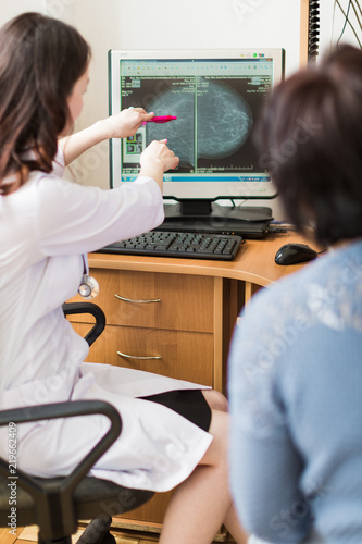 The young breast specialist showing the ultrasound examination on a monitor to the patient in her office