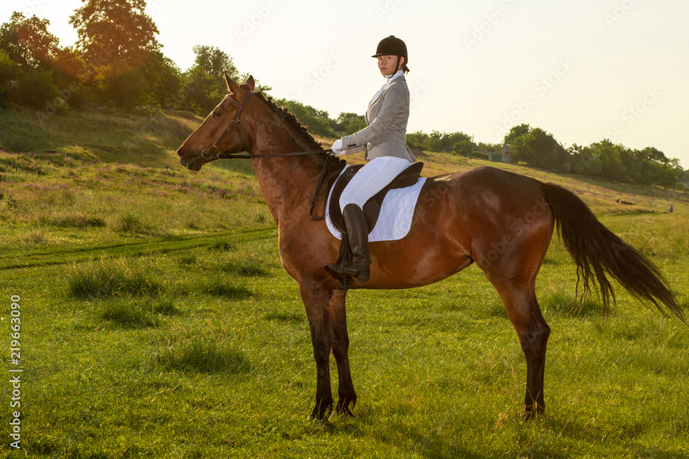 Young woman riding a horse on the green field Young woman riding a horse on the green field