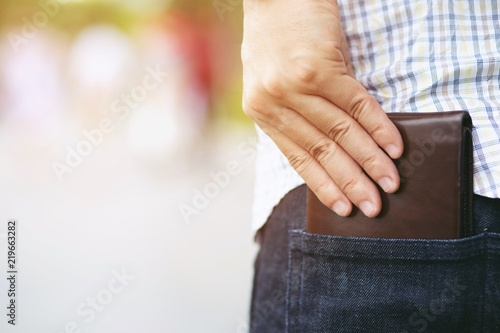 Confident man posing in safe keeping your wallet in the back pocket of his back pocket pants. savings money finance. 