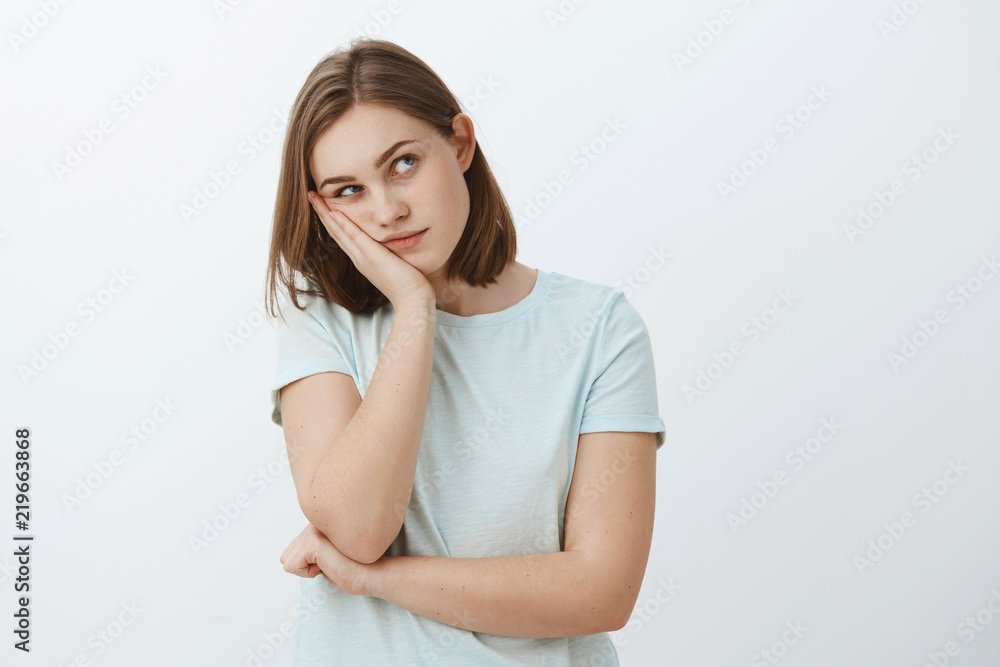 Girl thinks party lame. Bored young european female with short brown haircut leaning head on palm gazing at upper right corner thinking using imagination to entertain herself while dying from boredom Girl thinks party lame. Bored young european female with short brown haircut leaning head on palm gazing at upper right corner thinking using imagination to entertain herself while dying from boredom