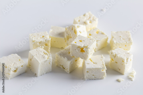 Feta cheese diced cubes stacked on white background - Close up image