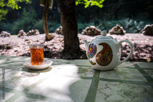 Eastern black tea in glass on a eastern carpet. Eastern tea concept. Armudu traditional cup. Sunset background. Selective focus
