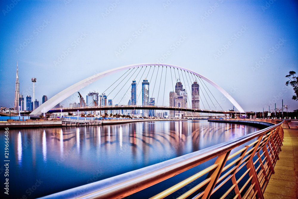 Obraz premium DUBAI, UAE - FEBRUARY 2018: Colorful sunset over Dubai Downtown skyscrapers and the newly built Tolerance bridge as viewed from the Dubai water canal.