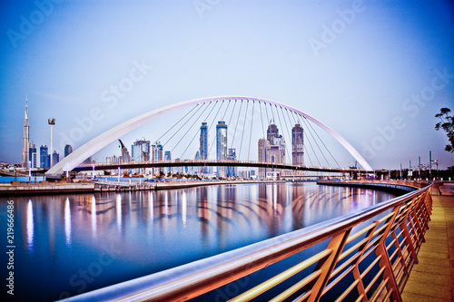 DUBAI, UAE - FEBRUARY 2018: Colorful sunset over Dubai Downtown skyscrapers and the newly built Tolerance bridge as viewed from the Dubai water canal.