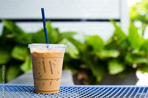 take-home cup with straw of ice coffee on streel  table