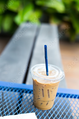 take-home cup with straw of ice coffee on streel  table photo