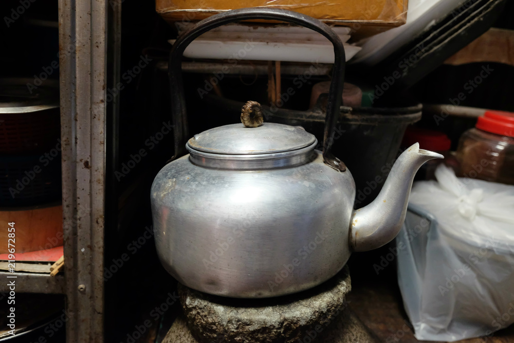 Old dirty vintage metal teapot or old kettle placed in the kitchen.