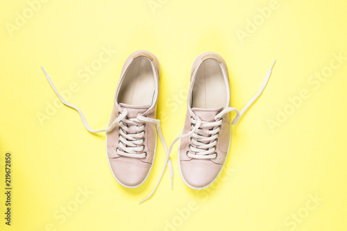 Woman fashion pink shoes on yellow background.