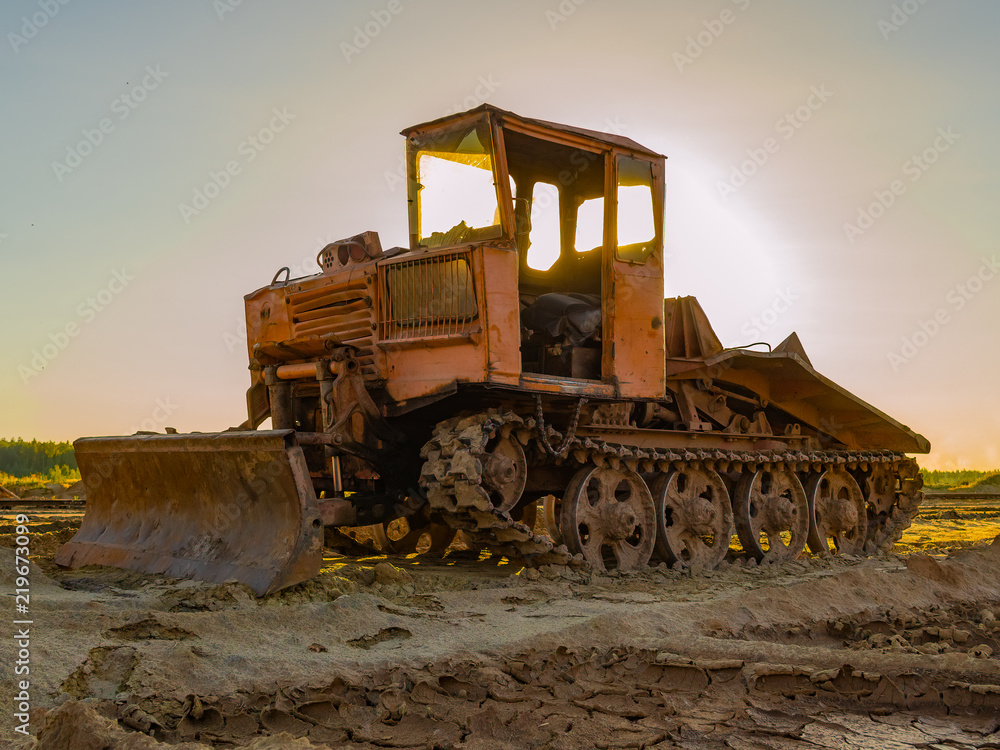 Vintage bulldozer. An abandoned old tractor with on sand quarry. Old tractor in the field