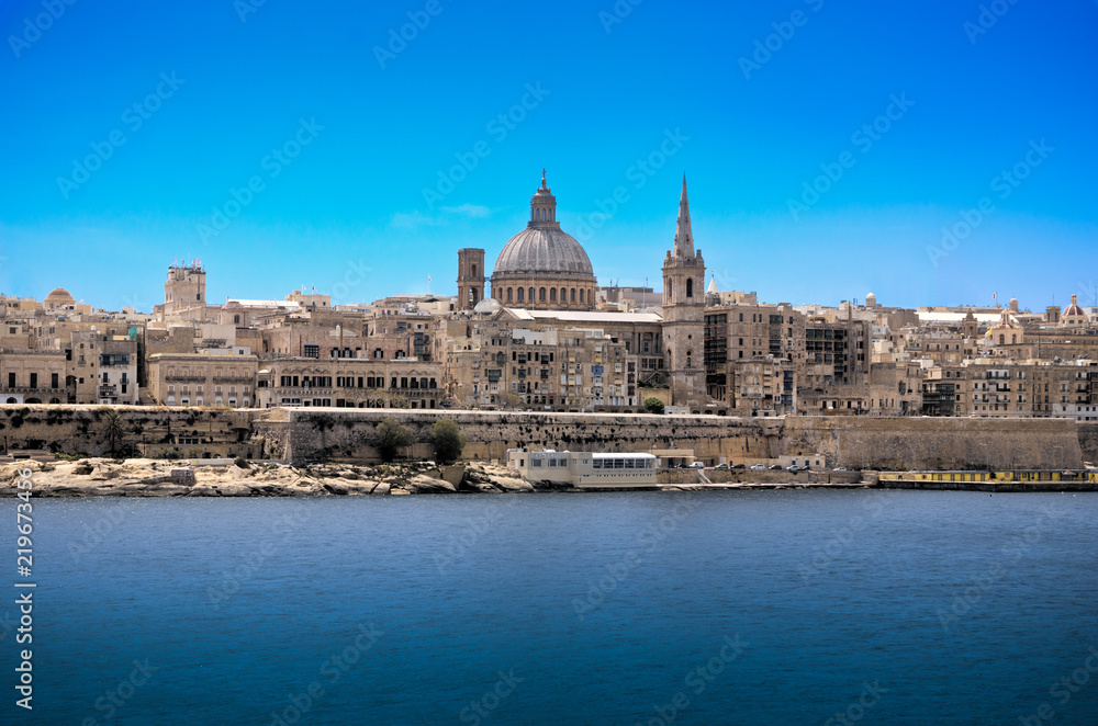 Old Valetta cityscape in mediterranean Malta island observed accross the harbour bay with visible cathedral dome