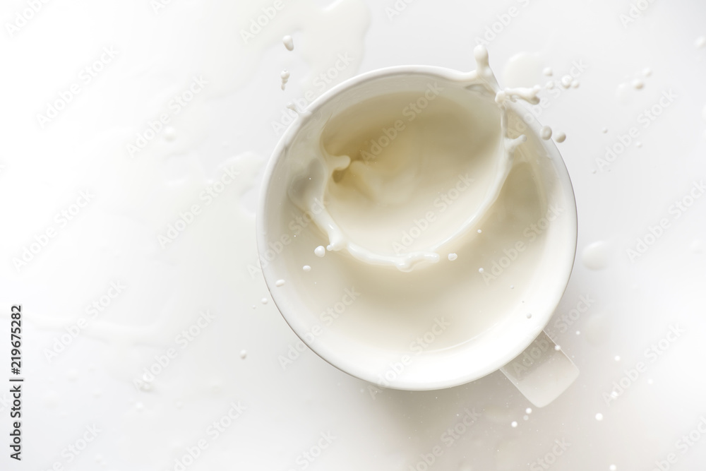 top view of milk splash out of glass on white background top view of milk splash out of glass on white background
