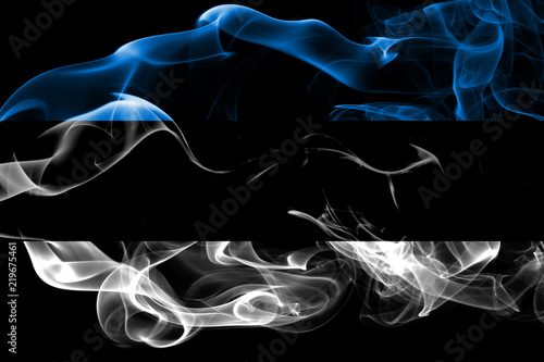 National flag of Estonia made from colored smoke isolated on black background. Abstract silky wave background.