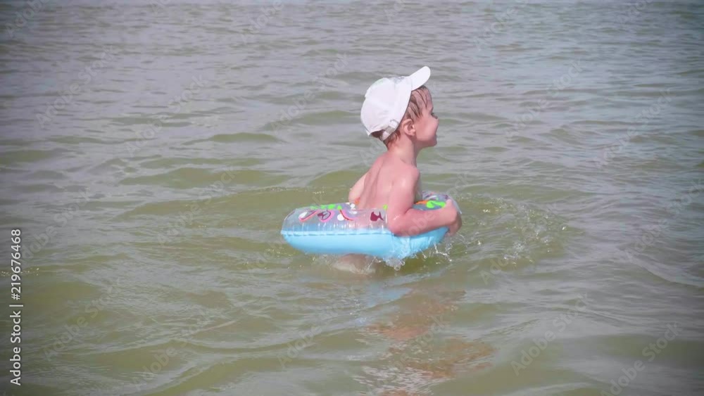 father with children swims on an inflatable circle in the sea. Happy ...