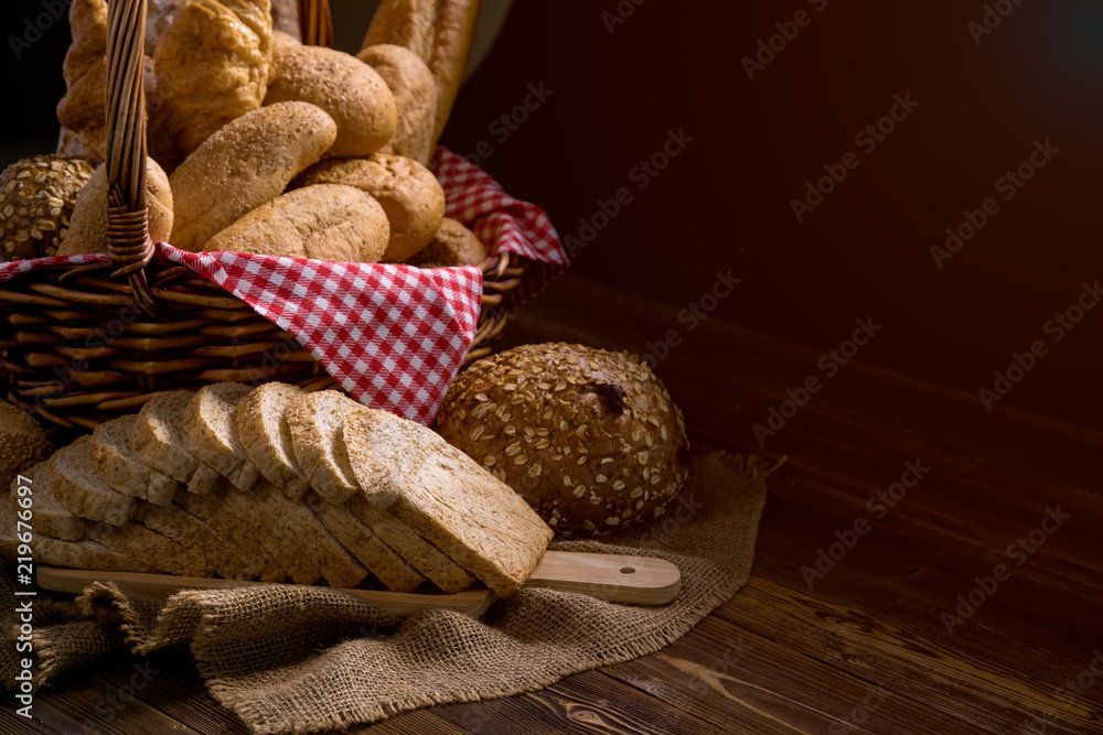 Close up of Baked Bread with basket; Various fresh bread such as sesame bun, baguette, baked rolls, croissant, round bun and whole grain sliced bread Close up of Baked Bread with basket; Various fresh bread such as sesame bun, baguette, baked rolls, croissant, round bun and whole grain sliced bread