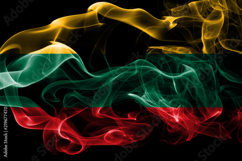 National flag of Lithuania made from colored smoke isolated on black background. Abstract silky wave background.