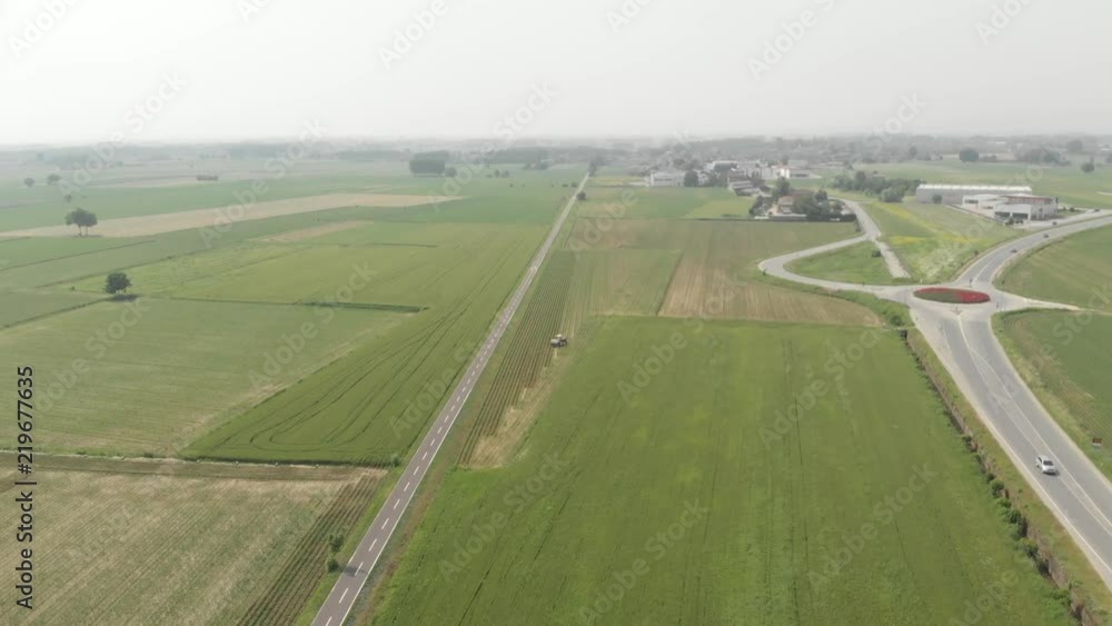Aerial: tractor working on cultivated fields farmland, agriculture occupation, top down view of cereal crops, sprintime in Italy. Native D-Cinelike ungraded color profile. Aerial: tractor working on cultivated fields farmland, agriculture occupation, top down view of cereal crops, sprintime in Italy. Native D-Cinelike ungraded color profile.