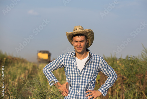 Farmer with combine harvester in field