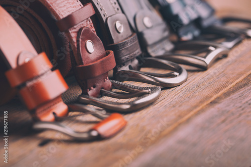 Leather belts on a wooden background. Fashionable leather belts. photo
