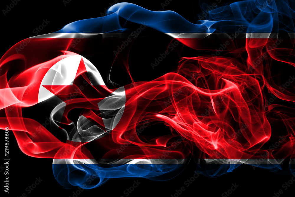 Fototapeta premium National flag of North Korea made from colored smoke isolated on black background. Abstract silky wave background.