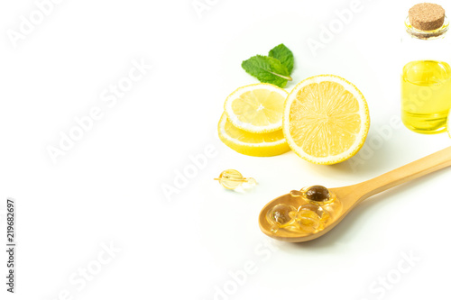 lemn fruit juice with bottle and peppermint leaf with wood spoon and vitamin on white background in beauty spa skin treatment healthy concept photo