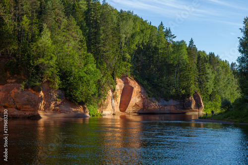 Peaceful landscape with Gauja river and red sandstone (Erglu klint) steep rocks in Gauja National Park in Valmiera area photo