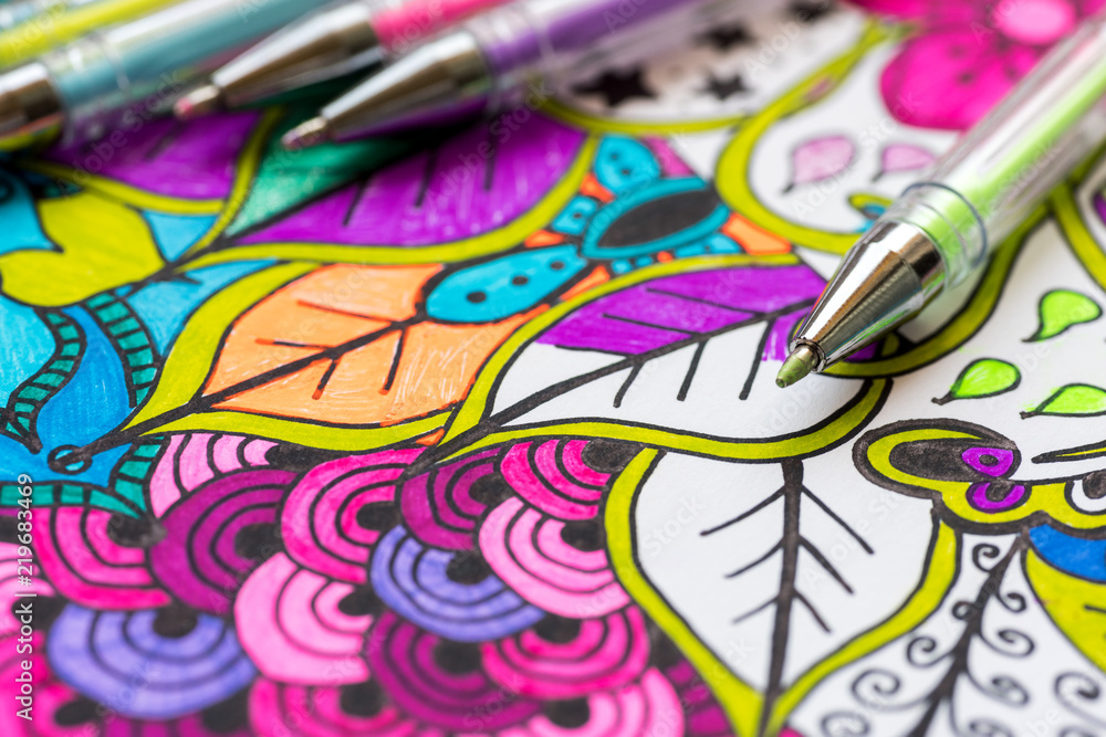 Obraz premium Adult coloring book, new stress relieving trend. Art therapy, mental health, creativity and mindfulness concept. Adult coloring page with pastel colored gel pen close up.