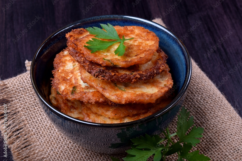 Vegetable pancakes topped with parsley leaves in a blue bowl Vegetable pancakes topped with parsley leaves in a blue bowl