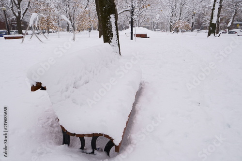 Wallpaper Mural First snow has fallen on everything during the night.  A  bench park is covered of snow in a public park. Torontodigital.ca