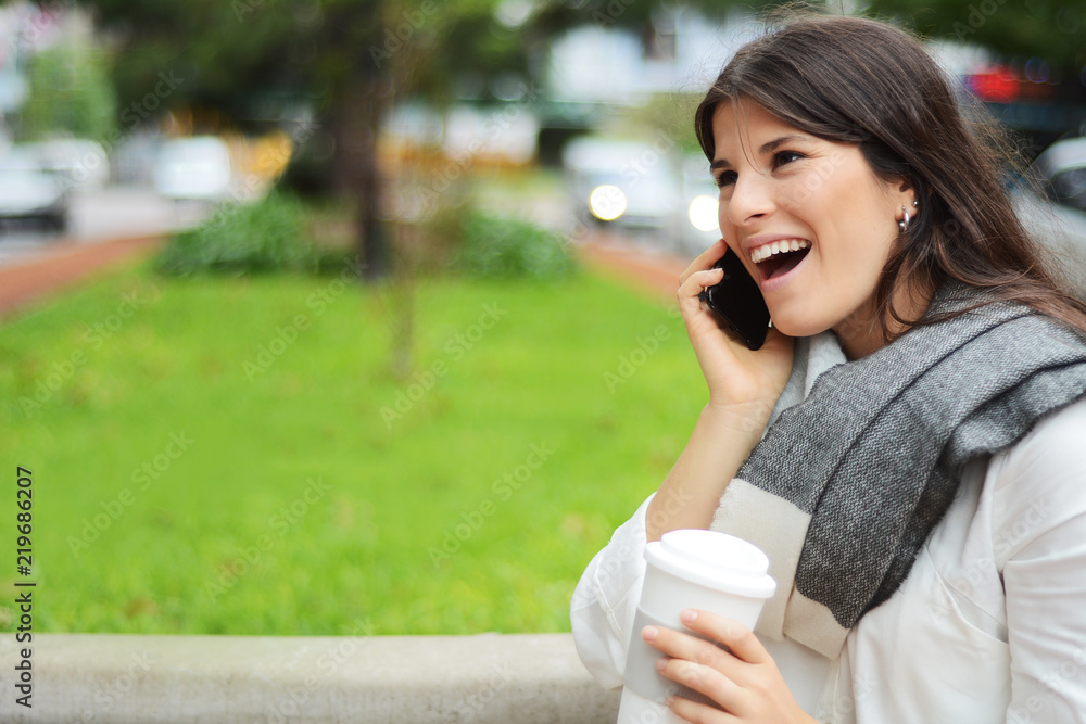 Young latin woman with her mobile phone and cup of coffee Young latin woman with her mobile phone and cup of coffee