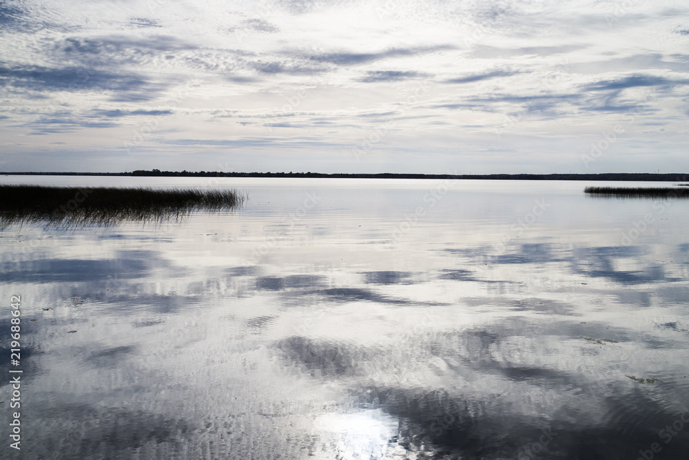 Fototapeta premium Sky and clouds reflecting in the lake at the end of the day.