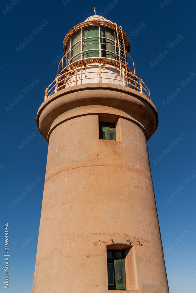 Exmouth, Western Australia - November 27, 2009: Closeup of Vlaming Head Lighthouse upper section, shaft and top, against deep blue sky.