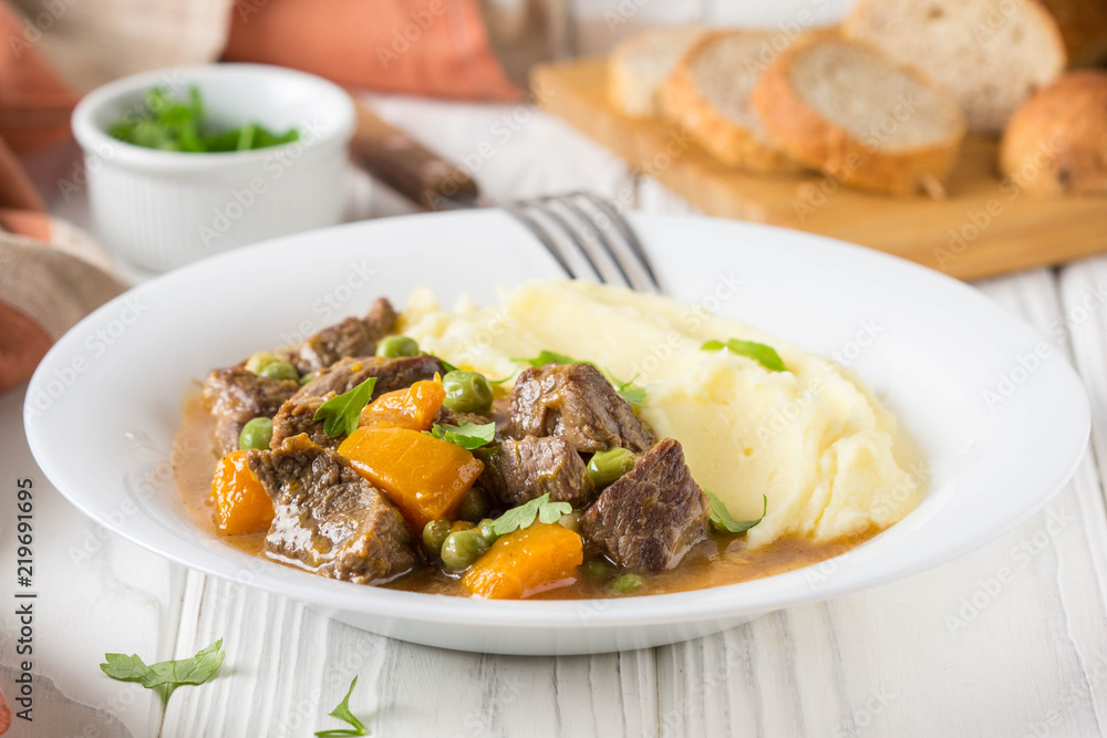 Beef stew, pumpkin and green peas with mashed potatoes. Delicious homemade dinner. Autumn food Beef stew, pumpkin and green peas with mashed potatoes. Delicious homemade dinner. Autumn food