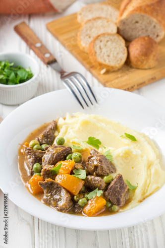 Beef stew, pumpkin and green peas with mashed potatoes.  Delicious homemade dinner. Autumn food