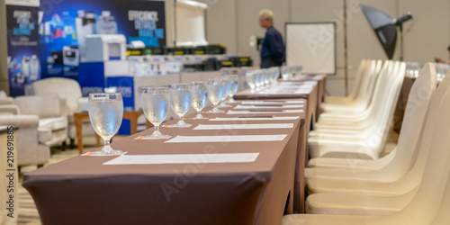 Row of table and chair with cold water glass at seminar meeting room.