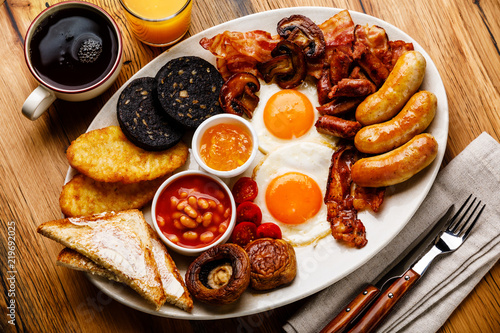 Photography Full fry up English breakfast with fried eggs, sausages, bacon, black pudding, b