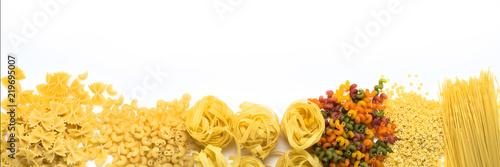 Italian pasta of various kinds on a white background. Flat lay, top view. Laid out in line. Banner