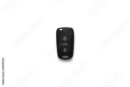 Black key ring with car key with remote control over white background