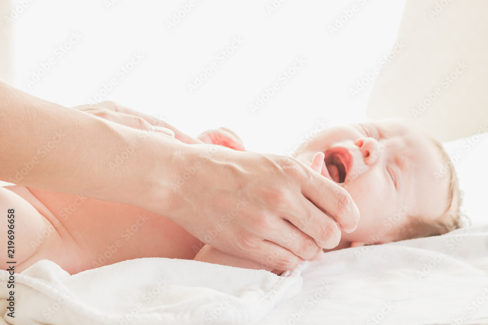 Baby and hands of mother, soft focus background Baby and hands of mother, soft focus background