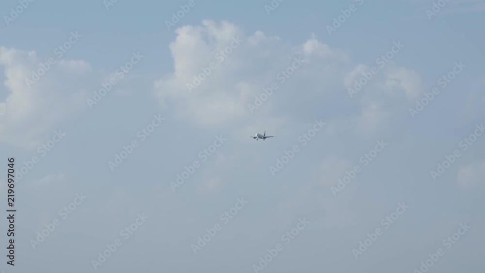 Jet plane approaching landing across blue sky, white clouds, handheld shot. Jet plane approaching landing across blue sky, white clouds, handheld shot.