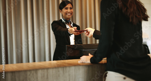 Concierge returning the documents to hotel guest