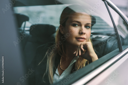Female executive travelling by a car