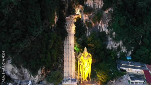 backsweep aerial of murugan statue by batu cave stairs photo